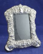 A 1990`s Edwardian style repousse silver photograph frame, with domed top and decorated with