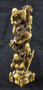 A Japanese ivory okimono netsuke, carved as three men, a boy and a goat perched on rocky outcrops,