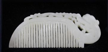 A Chinese white jade comb, of arched shaped, the top carved and pierced with a stylised dragon