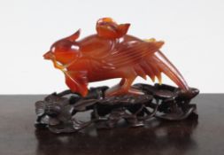 A Chinese chalcedony carving of a pheasant, early 20th century, the stooping birds grasping a flower