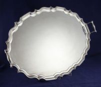 A George V Scottish silver two handled tea tray, of oval form, with wavy border, on acanthus leaf