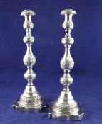 A pair of George V "Sabbath" candlesticks, with turned stems and engraved with foliate scrolls,