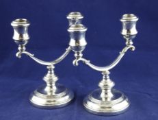A pair of 1960`s silver two branch two light candelabra, with leaf capped scroll arms and reeded