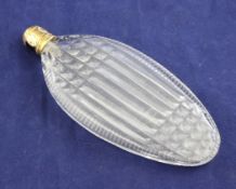 An early 19th century gold and enamel lidded oval cut glass scent bottle, unmarked, 5in. Starting