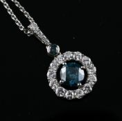 A white gold and two colour diamond target pendant, the central blue stone weighing approximately