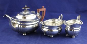 A 1930`s silver three piece tea set, of rounded rectangular form with gadrooned border, on bun feet,