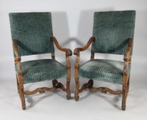 A pair of late 19th century French carved walnut open armchairs, with green padded back and matching
