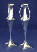 A stylish pair of Edwardian Art Nouveau silver posy vases, with tapered panelled stems and angular