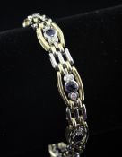 A late 1990`s 18ct two colour gold, sapphire and diamond line bracelet, with gate and tonneau shaped