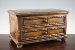 An 18th century South German carved and inlaid walnut table cabinet, of two long drawers on turned
