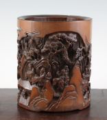 A Chinese bamboo brush pot, carved in high relief with sages amid rocky mountainous paths, with