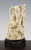 A Chinese ivory group of Shou Lao and a boy, early 20th century, the boy holding a peach in his