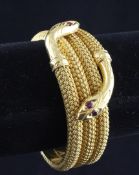 A modern Turkish? high carat gold twin serpent stiff bracelet, set with ruby eyes, with textured "