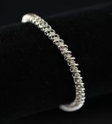 A 14ct white gold and diamond line bracelet, set with fifty one stones, 7in. Starting Price: £240