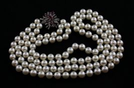 A double strand cultured pearl necklace with 14ct white gold and ruby set clasp, 24in. Starting