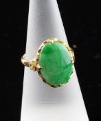 A Chinese gold and cabochon jadeite ring, with S-shaped shoulders, size M. Starting Price: £160