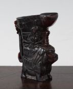 A Chinese horn rhyton cup, carved in relief with masks and bats, the base modelled as a lion-dog,