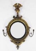 A Regency gilt gesso convex wall mirror, with eagle surmount and acanthus scroll decoration, mounted