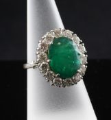 A 18ct gold and platinum set emerald and diamond oval cluster dress ring, with cage setting, the