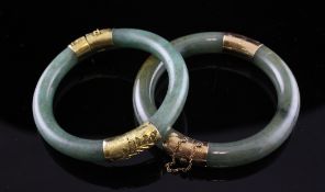 Two mounted jadeite stiff bracelets, one stamped 14ct, the other with gilt metal mount.
