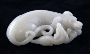 A Chinese white jade recumbent group of a hound and pup, carved in the round, the stone of good even