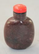 A Chinese pink rhodonite snuff bottle, 6cm., coral stopper