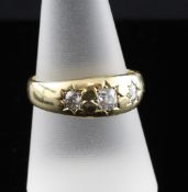 A Victorian 22ct gold gypsy set graduated three stone diamond ring, total estimated cushion cut