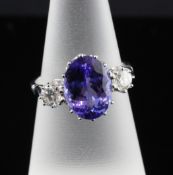 An 18ct white gold tanzanite and diamond three stone ring, with central oval cut stone flanked by