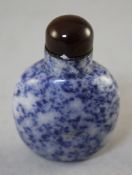 A Chinese sodalite snuff bottle, the stone with brown inclusions, 6cm., stopper