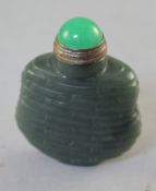 A Chinese green jade snuff bottle, carved in relief with basket weave design, 4.9cm., stopper
