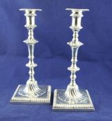 A pair of George III cast silver candlesticks by John Cox, with turned knopped tapering stems with