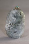 A Chinese green jade snuff bottle, carved as a lily pad to the back with twin fish amid lotus to the