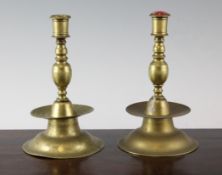 A pair of early 18th century style brass candlesticks, with broad base wax pans, 7.75in.