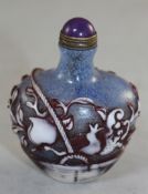 A Chinese red and white overlaid glass snuff bottle, carved in relief with a basket of fruit, on a
