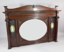 An Edwardian carved mahogany overmantel, with central oval mirror plate glass and two oval neo-