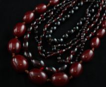 Six reconstituted red amber necklaces, four with gilt metal clasp, of varying sizes, with oval or
