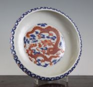 A Chinese porcelain `dragon` dish, Xuantong mark but later, decorated in iron red with two dragons