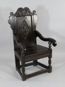 A 17th century joined oak Wainscot chair, with carved crest rail and lozenge panel back, probably
