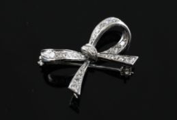 An 18ct white gold and diamond set ribbon brooch, 1in.