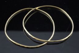 A pair of middle eastern gold bangles, with engraved decoration, unmarked, 61.1 grams.