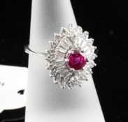 An 18ct gold ruby and diamond oval cluster ring, the central ruby bordered by two rows of