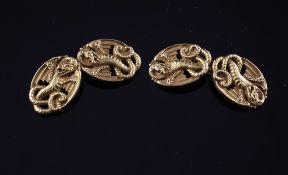 A pair of 14ct gold cufflinks, each oval link pierced and decorated with a dragon, in Goldsmiths &