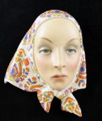 A Lenci pottery polychrome wall mask, of a female with headscarf, from a model by Helen Scavini,