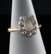 An 18ct gold and diamond horseshoe shaped ring, set with nine stones, size L.