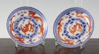 A pair of Chinese `dragon` saucer dishes, Qianlong seal mark but c.1900, each painted in iron red