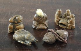 A Japanese boxwood netsuke of three sages seated at a table, two character signature, 1.75in.,