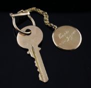 A gold key with chain and disc shaped fob engraved "Capri 23rd July, 1965", unmarked, gross 29