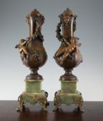 A pair of early 20th century bronze, spelter and green onyx urns, decorated with cherubs, 19.5in.