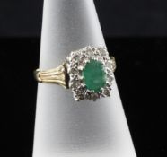 A 1980`s 9ct gold, emerald and diamond set cluster ring, size M