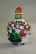 A Chinese five colour overlaid glass snuff bottle, decorated with sages seated below pine trees amid